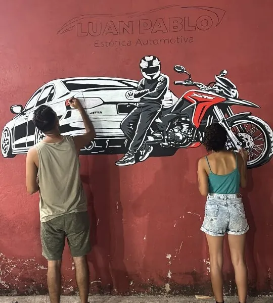 Mural com carro e moto pintado na parede da oficina
